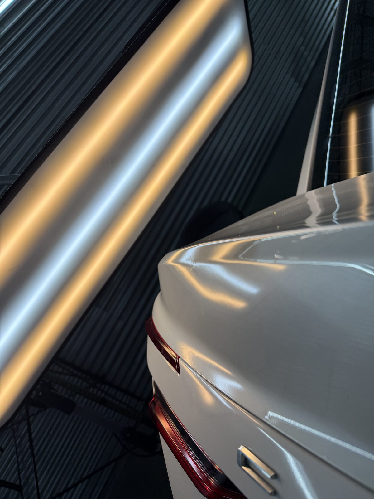 Technician reading a dent under a PDR inspection light